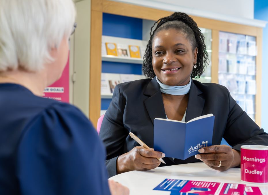 Business savings specialist smiling with a customer as they discuss their business savings options.